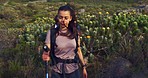 Hikers walking a trail on a mountain with hiking sticks. Diverse group of active and adventurous backpacking friends exploring a rugged path in nature. Tourists enjoying a scenic trek outdoors.