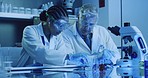 Two laboratory scientists pouring chemical solution into a monkeypox petri dish to examine reactions for medical research. Biochemist colleagues wearing goggles and discovering a cure in a uv lit lab