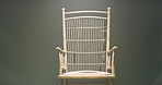 Closeup of a wicker chair in studio isolated against a grey background. Minimalist furniture for modern decorative and simple seating purposes. A comfortable place to sit when you need to rest