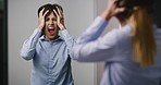 Scared schizophrenia patient shouting while looking in an asylum mirror. Woman suffering from bipolar disorder, feeling stressed, anxious, crazy. Mentally ill with dissociative personality disorder