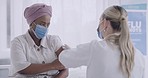 Doctor injecting a patient with the covid19 vaccine at hospital. Two woman wearing masks and protecting themselves from the spread of disease. Nurse talking to a nervous patient after receiving shot 