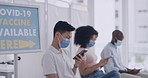 People waiting in line for a covid vaccine in a hospital or clinic. Patients texting and browsing on their phones while sitting in a queue for a booster shot for immunity to diseases in a pandemic