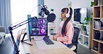 Trendy woman vlogger records podcast in modern home. Young podcaster with headphones recording an audio podcast for social media followers. Broadcast radio host or influencer streaming live content