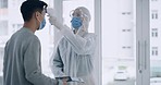 A doctor takes and measures patients' temperatures using a non contact infrared thermometer in a hospital. A man and woman wearing masks and getting scanned for coronavirus or monkeypox symptoms