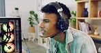 A concentrated gamer playing a video game on his computer monitor with latest headset gear. Young trendy guy playing esports on multiplayer mode and challenging his components via a microphone