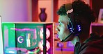 A young skilled gamer playing online games with a headset and colorful lighting broadcast streaming live at home. Esports male gamer skillfully playing online with friends speaking on a headset.