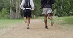 Fit couple running in a forest and on a dirt road path. Active, athletic boyfriend and girlfriend bonding, training, exercising and jogging in social run in the woods. Man and woman in nature workout