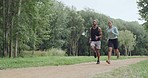 Fit couple running and jogging in the park on a sunny day. Motivated and determined young athletes pacing their steps for a cardio workout. Exercising on a trail in nature to stay healthy and fit