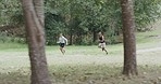 Fit couple running a trail in a park or forest outdoors. Motivated and determined young athletes striding with speed to increase endurance and stamina during a cardio training workout in nature
