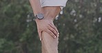 Male athlete suffering from a sports injury while standing outside. A sportsman massaging his pulled calf muscle or leg to ease the pain after a run. Fitness and exercise comes with the risk of pain