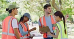 Group of volunteers preparing to clean the park. Team council leader or activist with a checklist clipboard, doing project management of community workers and assigning tasks in a green environment