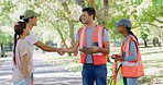 Volunteers handing out reflector jackets to the public to help clean a park. NGO employees greeting and meeting people outdoors for community project. Man and woman joining a cleaning campaign