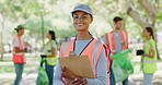 Female volunteer with a clipboard in the park leading a group of responsible activists doing charity work by cleaning up litter in the community. Caring for a sustainable, clean and safe environment