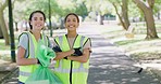 Portrait of two young volunteers uniting for a cleanup service or project outdoors. Young happy community workers smiling while collecting trash in a park, doing their part to protect the environment