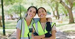 Portrait of two young community workers uniting for a cleanup service or project outdoors. Young happy volunteers smiling while collecting trash in a park, doing their part to protect the environment