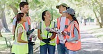 Group of diverse young community workers uniting for a cleanup service or project outdoors. Young happy volunteers talking while collecting trash in a park, doing their part to protect the environment