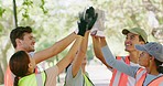 Volunteers uniting for high five, diverse community workers together for cleanup service or project outside. Happy while talking and planning on strategy to collect trash and protect the environment 