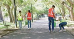 Volunteers cleaning litter in a community park. Activists doing charity work by conducting a neighborhood cleanup and recycling initiative to reduce pollution for a sustainable and safe environment