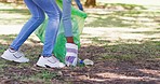 Closeup of an environmentalist cleaning the park for an eco friendly planet. Responsible volunteer, activist or council worker throwing recycling or reusable material into a green plastic rubbish bag