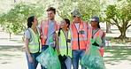 Portrait of happy young people cleaning a park in an eco friendly community. Diverse group of responsible activists and volunteers collecting litter for a sustainable, clean and safe environment
