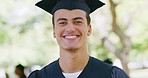 Portrait of a young student at graduation. A young cheerful male scholar standing in a robe and cap feeling confident after completing his diploma, certificate or degree e at a university or college 