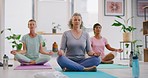 Mature women meditating in lotus pose in zen yoga class. Diverse group of yogis sitting together on mats, legs crossed, finding inner mental balance and peace. Practising calming breathing exercises
