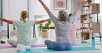 Mature women meditating with raised prayer hands in zen yoga class. Diverse group of yogis sitting on mats, legs crossed, finding inner mental balance or peace. Practising calming breathing exercises