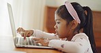 Little girl learning to type on a laptop at home. Child working and interacting online during a virtual class lesson. Preschooler enjoying amazing, fun educational activity on using modern technology