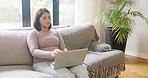 Tired and stressed woman using her laptop and being disturbed by her kids. Energetic sibling sisters joining their mother on the couch. Mom needs privacy and alone time while using the internet