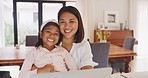 Portrait of a young mother relaxing and using a laptop with her daughter at home. Smiling little girl browsing a pc and watching videos with her mom. Parent and child searching the internet together