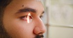 Closeup of a slit lamp machine testing a patient's eye or pupil reflex during an optician consult. Headshot of a man visiting optometrist, using LED light to examine astigmatism and retina reflection