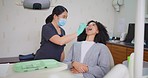 Dentist with face mask checking teeth of female patient with mirror tool during dental appointment. African woman having routine checkup to prevent tooth decay and gum disease with good oral hygiene