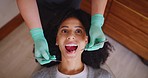 Dentist checking mouth of female patient during a dental appointment from above. African woman having her routine checkup to prevent tooth decay and gum disease. Good oral hygiene means healthy teeth