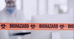 Orange biohazard barrier tape blocking and barricading a secured office space as a caution for disinfection of covid. Team of workers in protective coveralls sanitizing and cleaning a prohibited area