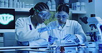 Two laboratory scientists testing phenolphthalein chemical reaction with a petri dish and pipette in an ultraviolet lab. Serious doctors with protective glasses, researching a cure for a pandemic