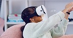 Trendy woman wearing a VR headset and touching interface with her hands. Young female with futuristic virtual reality goggles, playing an interactive 3D simulation game and experiencing the metaverse
