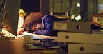 Tired female accounting manager sleeping at a desk in front of her computer. Young, modern business worker asleep in the dark after a hard day at the office. Employee working late at her workplace.
