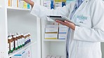 Pharmacist using digital tablet while checking prescription medication at a pharmacy. Medical professional, chemist or pharmaceutical worker doing inventory of medicine stock at a healthcare clinic