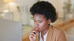 Assistant looking serious while working on a desktop computer alone in an office. One black female secretary reading an email and checking her schedule while sitting at a desk and browsing on a pc