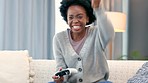 Happy female gamer cheering after winning an online video game. Young woman playing a multiplayer game and finishing or completing a checkpoint. Celebrating with a fist pump and happy expression