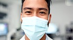Portrait of a scientist wearing a face mask in a research lab. Closeup of a happy pathologist or doctor smiling while looking confident in finding a cure. Man wearing protective covering for safety

