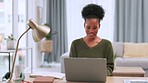 Portrait of a black woman working remotely on a laptop from home. Happy business woman smiling and browsing online while doing research and planning. Confident freelance entrepreneur blogging online