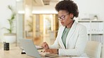 Young business woman browsing on a laptop while working in an office. Focused entrepreneur thinking while typing emails and compiling online reports. Doing research and planning in a startup company
