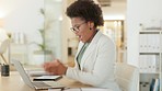 Happy young business woman shouting and cheering while working on a laptop in an office. Cheerful and excited african entrepreneur smiling while celebrating a success and a completed or finished task