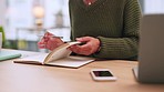 Hands of writer paging through notebook and writing on clean page in her office. Female entrepreneur or journalist making notes of ideas and plans for her next story. Female student making a list