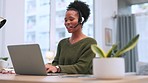 Young black female call centre agent talking on a headset while working on a laptop in an office. Confident African American consultant operating a helpdesk for customer service and support