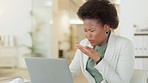 Young business woman sneezing and feeling sick while working on a laptop in modern office. Professional worker suffering from flu symptoms, allergy or sinus, coughing and wiping her nose at her work