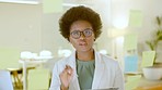 Young business woman walking to and brainstorming on a glass wipe board in her office at work. Female corporate professional thinking of ideas and planning a strategy for success using sticky notes. 