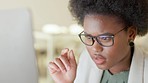 Businesswoman with glasses reading information on a computer screen while working in an office. Closeup of one confident young entrepreneur pointing while carefully analyzing reports and plans online