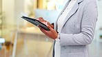 Digital tablet, closeup hands of business woman typing an email on a mobile device while standing in an office. Corporate worker staying connected and sending a message on communication app